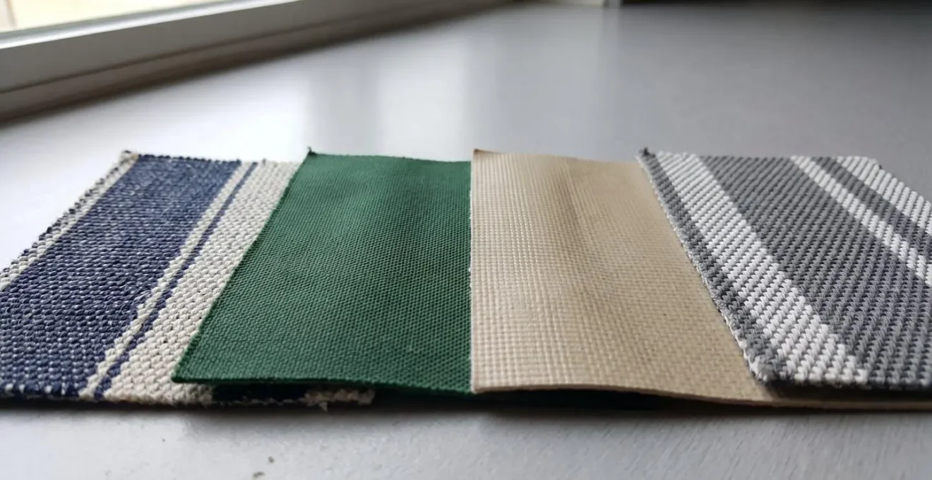 Gros plan sur échantillons de toiles de protection solaire montrant les différences de tissage et de densité des matériaux