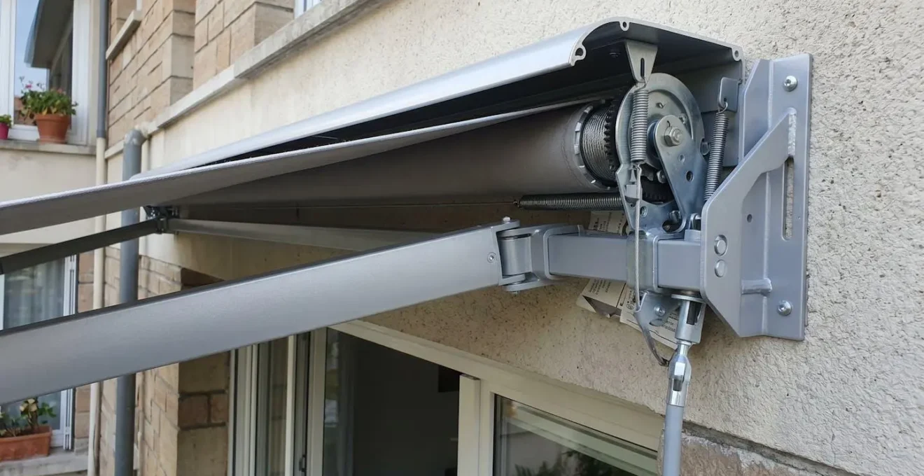 Gros plan sur mécanisme et bras articulés en aluminium d'un store banne montrant la structure de renfort