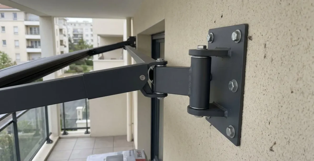 Gros plan sur mécanisme et bras articulés en aluminium d'un store banne montrant la structure de renfort